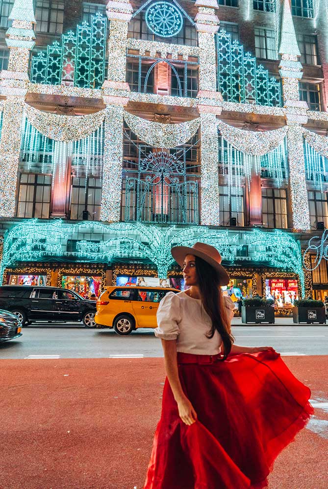 Kristi Hemric (Instagram: @khemric) crosses in front of the Saks Holiday Light Show on 5th ave in NYC