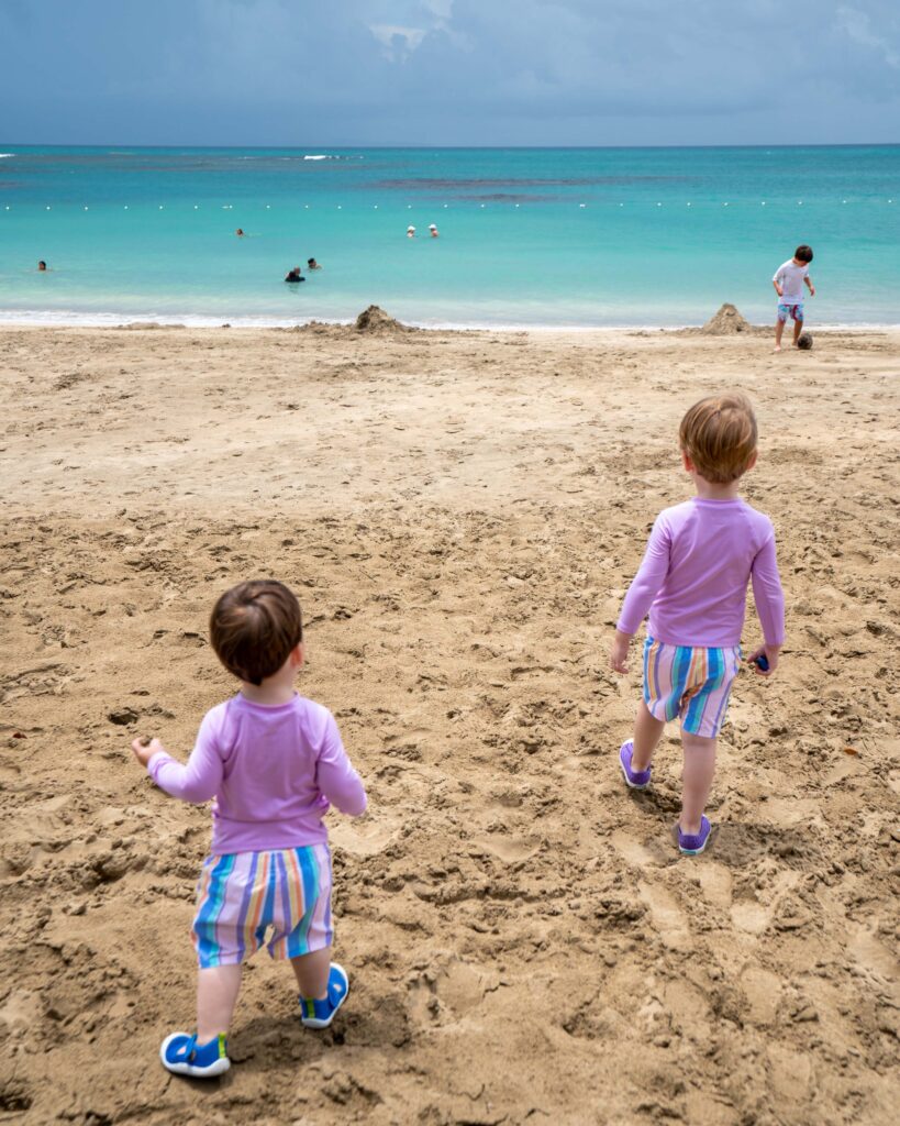 Pierce and Theo on a sandy beach heading towards the water at Club Med Miches